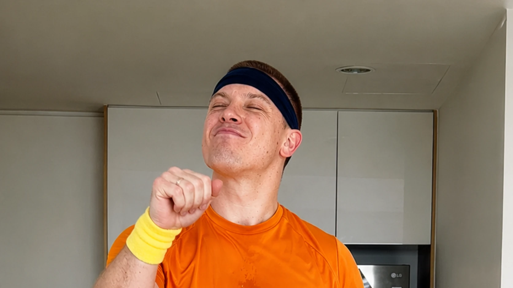 Dopamine Steps host doing a standing knee lift at home